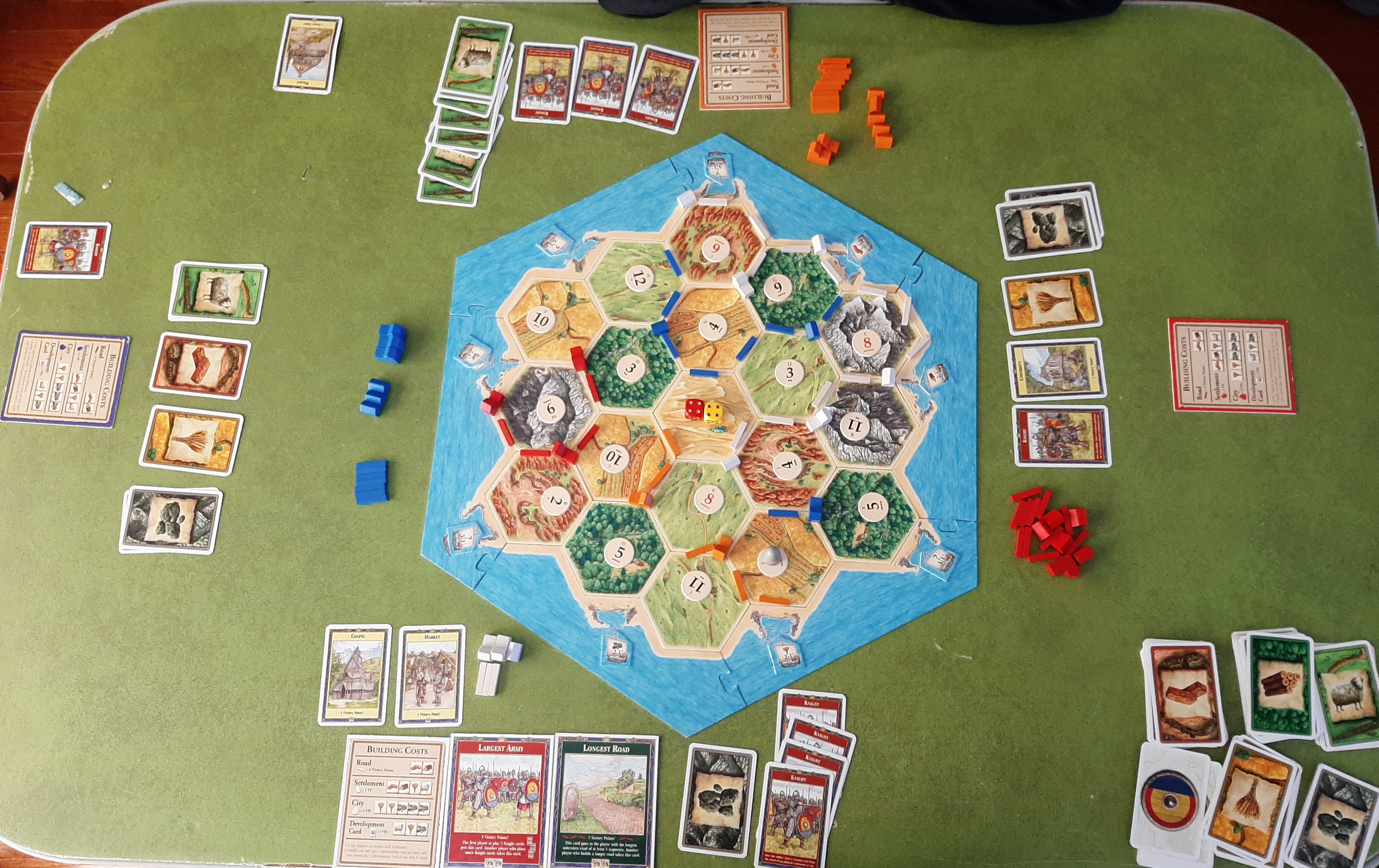 Mesa de jogo de Catan montada com vilas, cidades e estradas